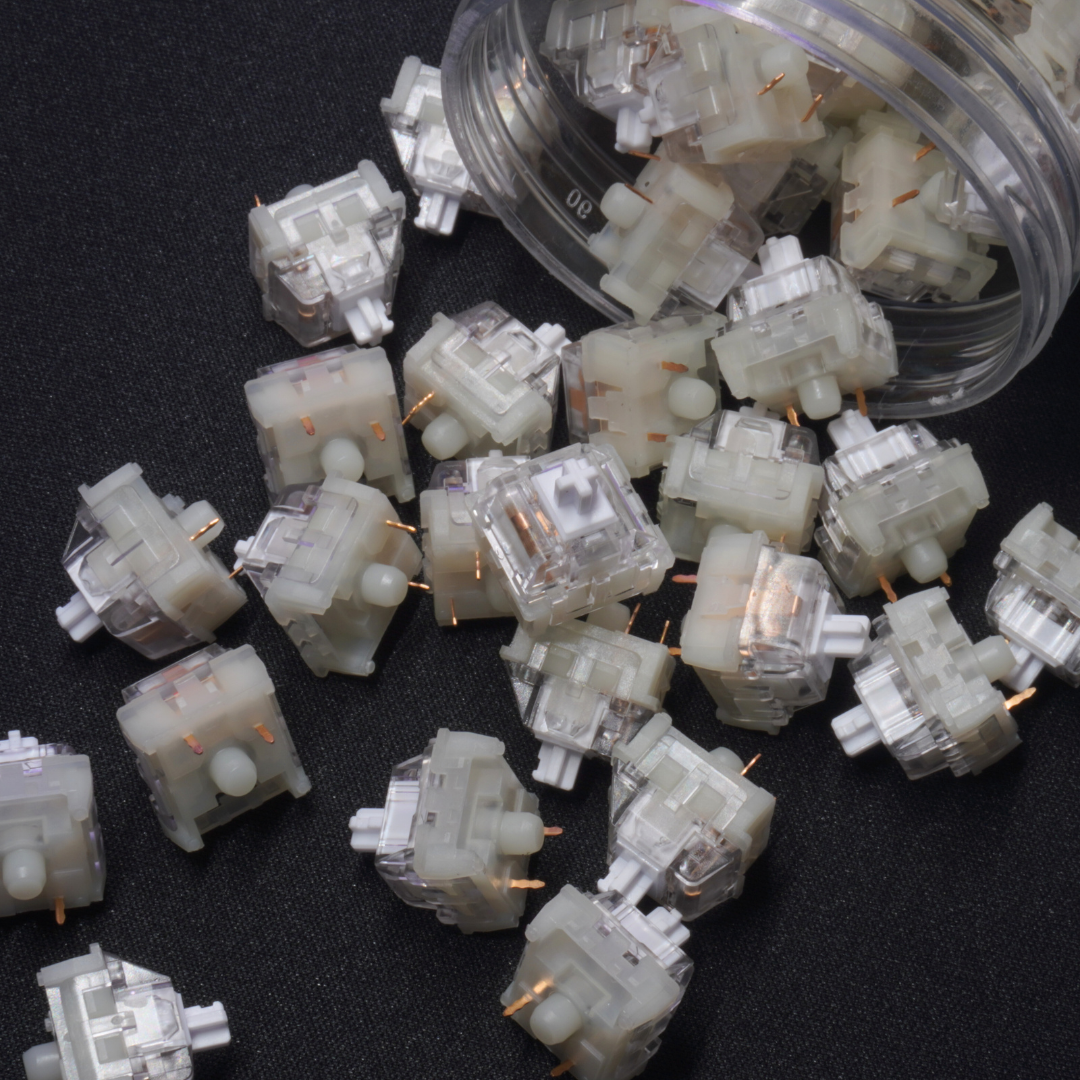 A close up photo of lots of GGBoy Creamy White V3 Linear Switches falling out of a jar in a pleasant way