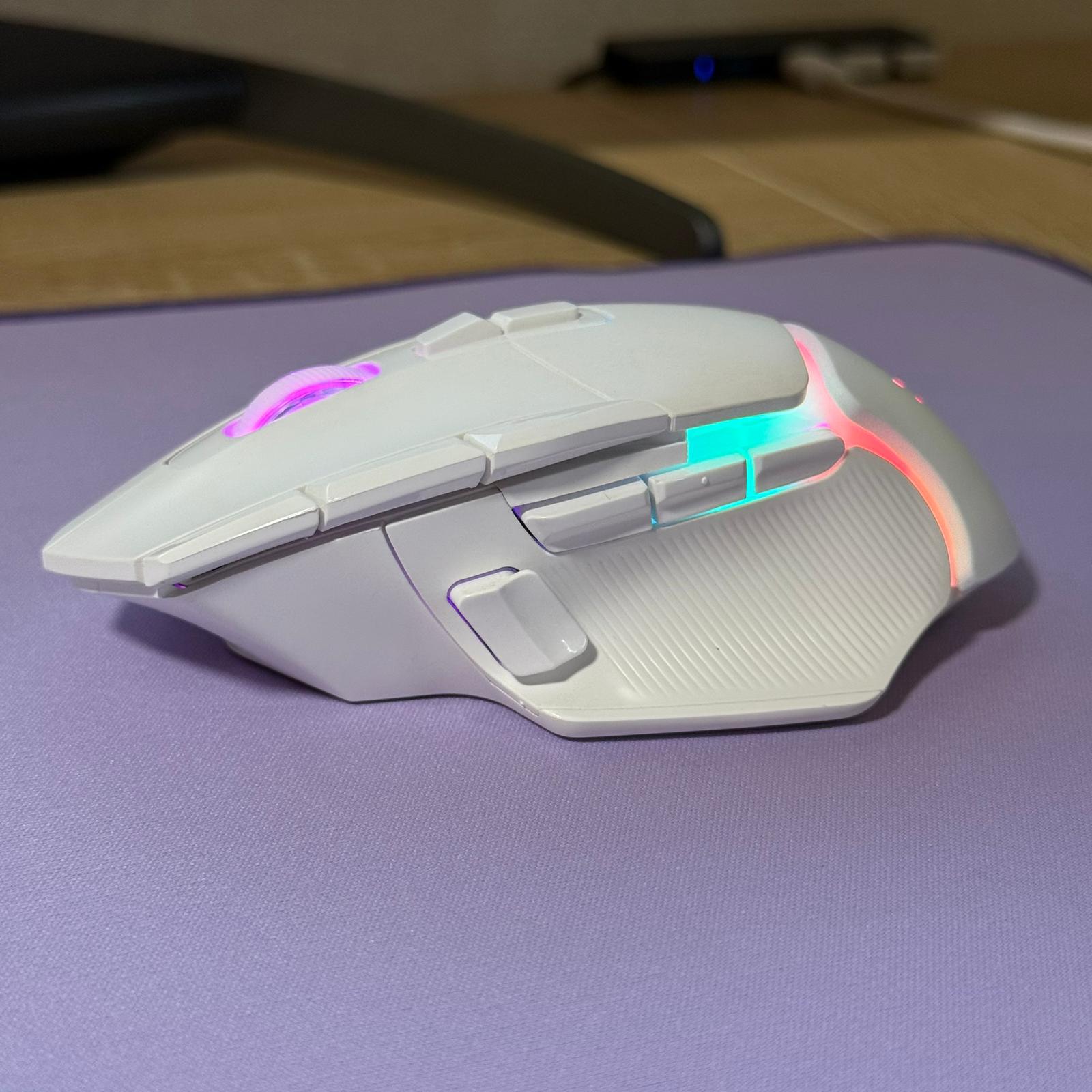 Gaming mouse with RGB lighting on a purple surface