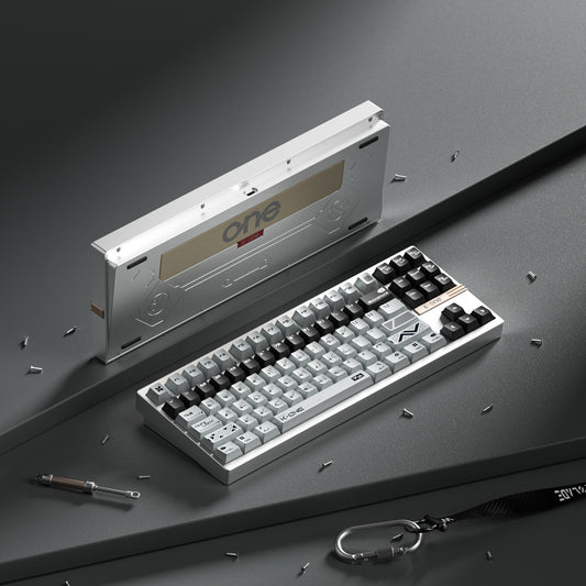 Mechanical keyboard with a tool and keychain on a gray surface