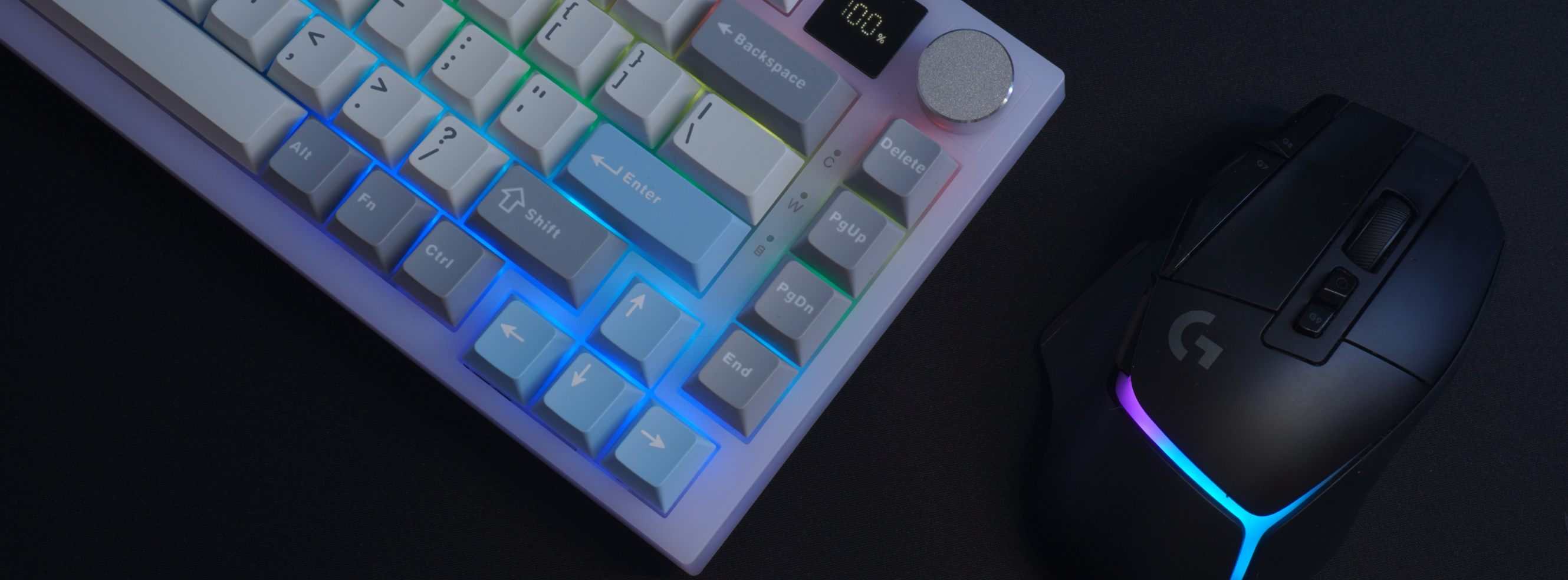 This is a detail photo of our What The Thock Bubbly75 75% Mechanical Keyboard in the transparent color on a desk with a Black desk mat and gaming mouse, taken from above on a 45degree angle