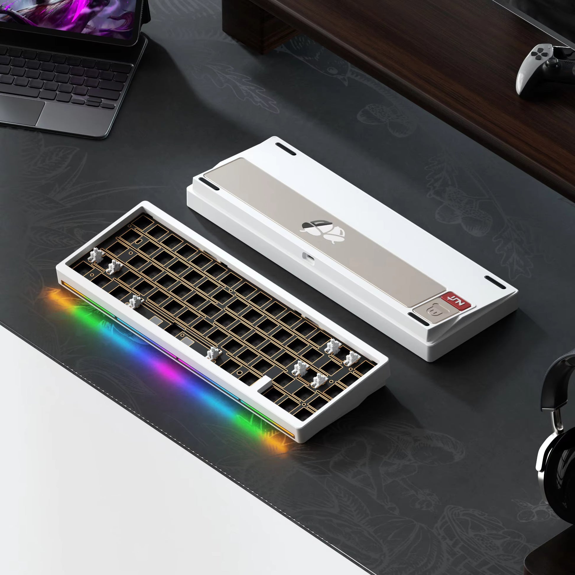 Mechanical keyboard with RGB lighting on a desk with a laptop and headphones.