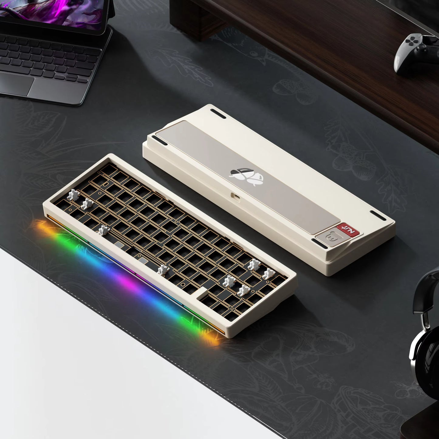 Mechanical keyboard with RGB lighting on a desk with a laptop and headphones.