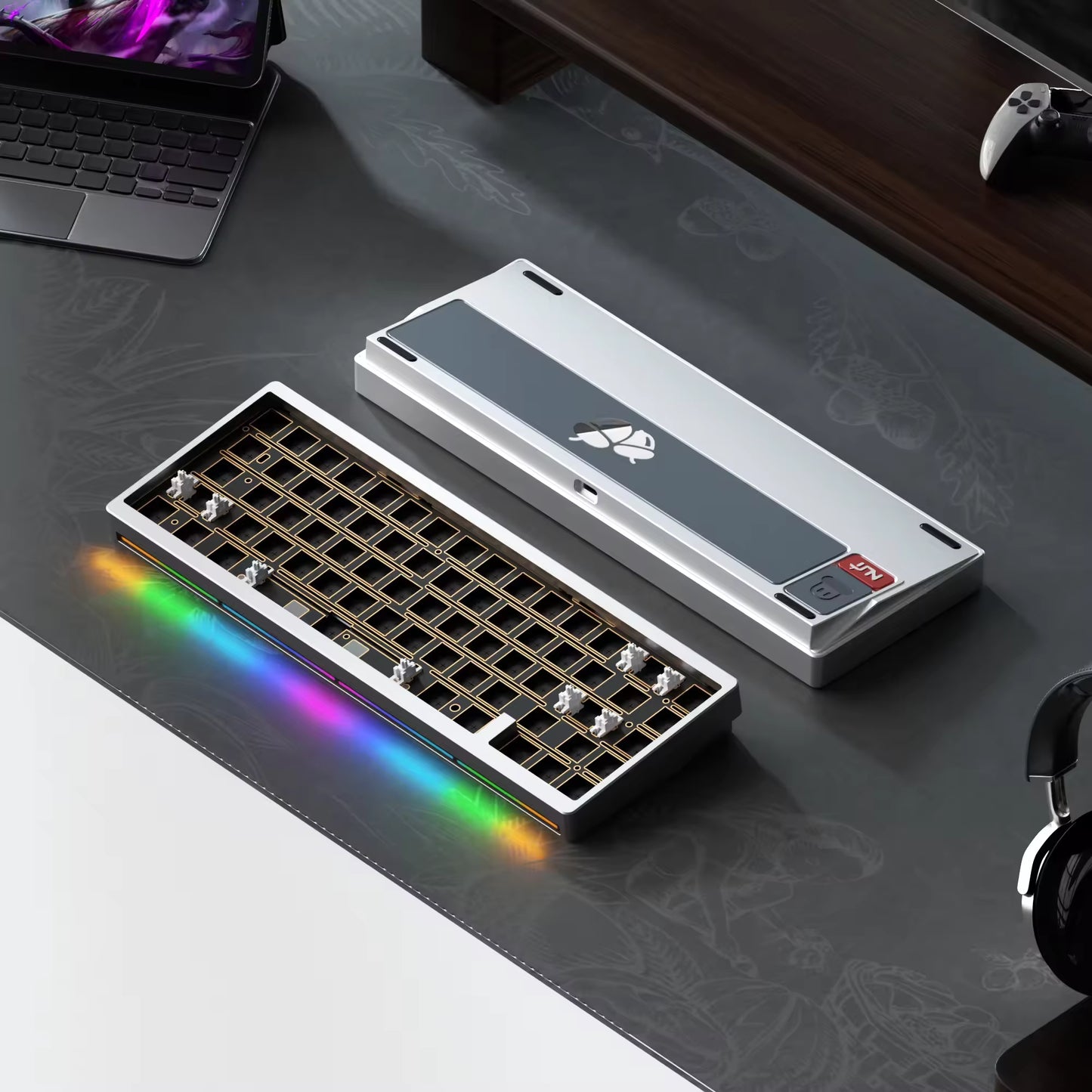 Modular keyboard with RGB lighting on a desk with laptop and headphones.